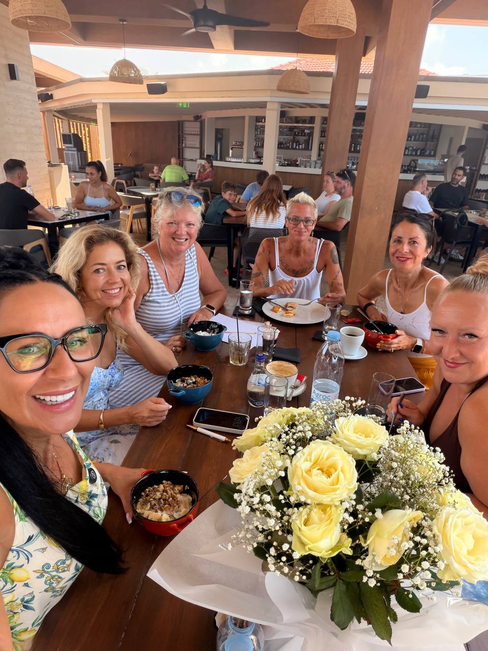 A group selfie of the WPA women with flowers on the table, 7 August 2026